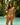 Woman in a colorful bikini standing by a pool with tropical foliage in the background