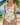 Woman wearing a colorful swimsuit on a beach with palm trees and ocean in the background