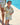 Child and adult wearing matching floral outfits by a poolside